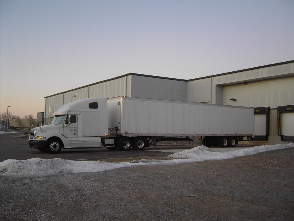 Semi truck with dry van trailer at a warehouse dock